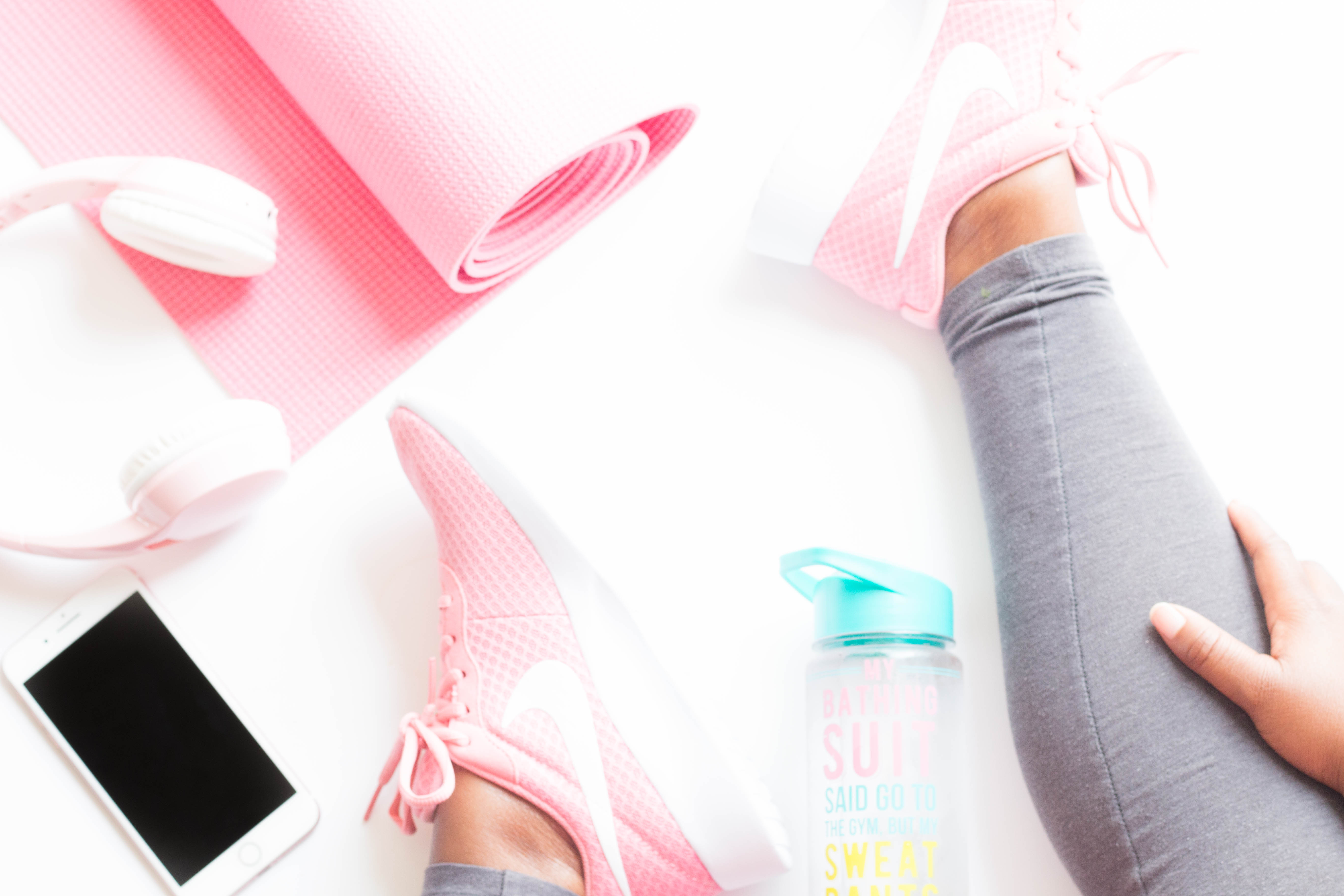 Flat lay with yoga mat, head phones, iphone, water bottle. Luara from Mom Connection helps help moms lose weight and talking about why moms have a hard time losing weight.